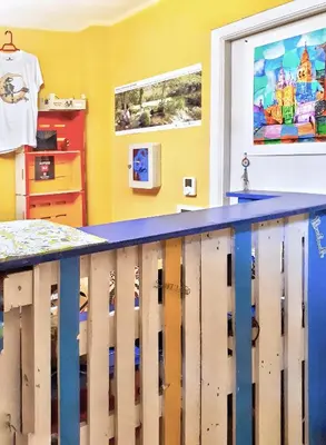 a childs room with yellow walls and a blue railing at Meiga Backpackers Hostel in Santiago de Compostela