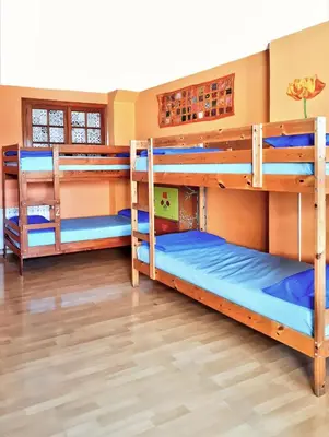two bunk beds in a room with wood floors at Meiga Backpackers Hostel in Santiago de Compostela