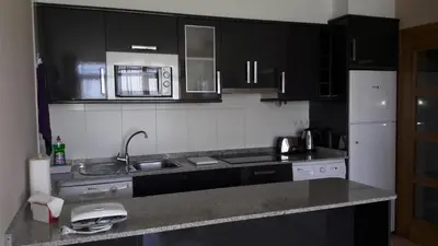 a kitchen with black cabinets and a sink and a refrigerator at Panoramico Playa de Altar I in Barreiros