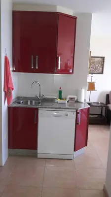 a kitchen with red cabinets and a sink at Panoramico Playa de Altar II in Barreiros