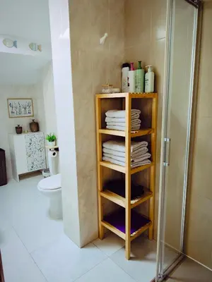 a bathroom with a shower and a shelf with towels at Buen Camino Arzua in Arzúa