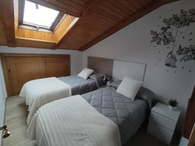 a bedroom with a large bed and a skylight at Buen Camino Arzua in Arzúa