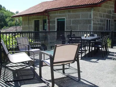 a group of chairs and tables in front of a building at Casa en Viñoas (Ribeira Sacra) in Viñoás