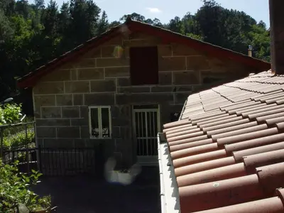 a stone house with a red roof at Casa en Viñoas (Ribeira Sacra) in Viñoás