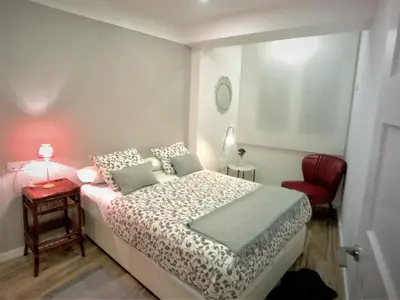 a bedroom with a bed and a red chair at 4 Apartamentos de Autor in Lugo