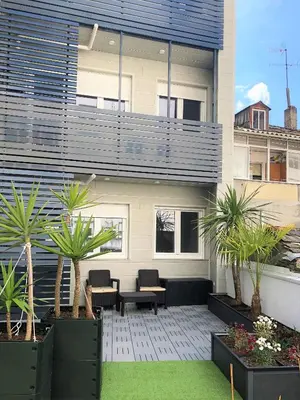 a patio with palm trees in front of a building at 4 Apartamentos de Autor in Lugo