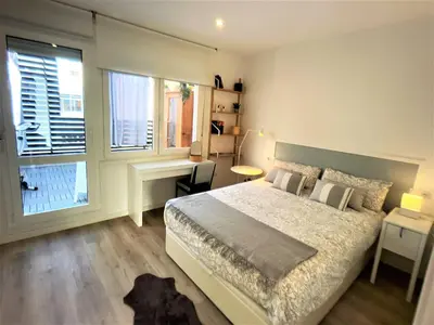 a bedroom with a bed and a desk and two windows at 4 Apartamentos de Autor in Lugo