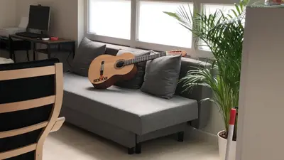 a guitar sitting on a couch in a living room at Albergue SIXTOs no Caminho - NO BIKE STORAGE in Santiago de Compostela
