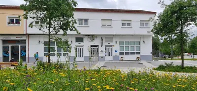 a white building with flowers in front of it at Albergue SIXTOs no Caminho - NO BIKE STORAGE in Santiago de Compostela