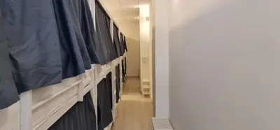 a hallway with a long row of hanged clothes at Albergue SIXTOs no Caminho - NO BIKE STORAGE in Santiago de Compostela