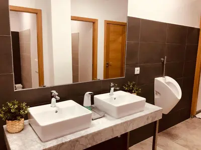 a bathroom with two sinks and a urinal at Albergue SIXTOs no Caminho - NO BIKE STORAGE in Santiago de Compostela