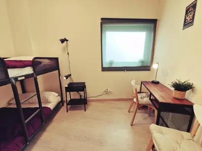 a room with bunk beds and a desk and a window at Albergue SIXTOs no Caminho - NO BIKE STORAGE in Santiago de Compostela