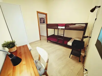 a room with a desk and a table with a bed at Albergue SIXTOs no Caminho - NO BIKE STORAGE in Santiago de Compostela
