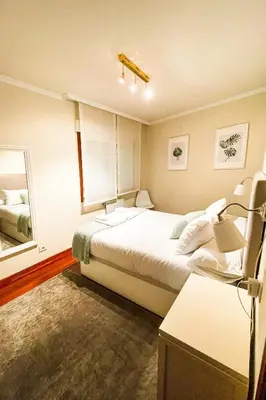 a bedroom with a large bed and a mirror at Miranda VUT-PO-004637 in Caldas de Reis