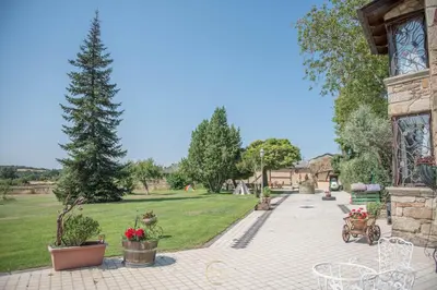 a patio with a park with a tree and chairs at Villa Rural 