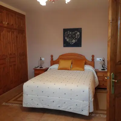 a bedroom with a bed with a wooden headboard at Casa Rural Leonor in San Ciprián