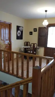 a living room with a wooden staircase and a table at Casa Rural Leonor in San Ciprián