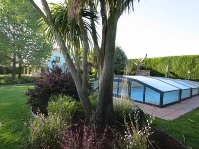 a glass house with a solar roof in a garden at Casa da Agra in A Coruña
