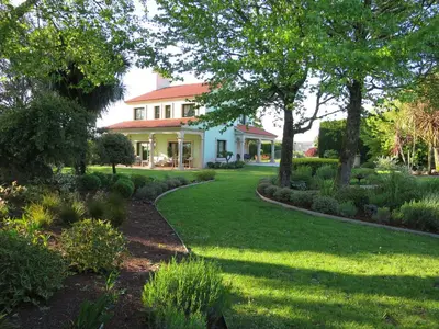 a garden with a house and trees and grass at Casa da Agra in A Coruña