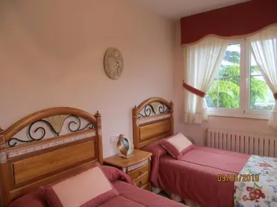 a bedroom with two beds and a window at Casa da Agra in A Coruña
