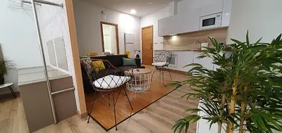 a living room with a couch and chairs and a kitchen at Apartamentos Antares 2 in Milladoiro