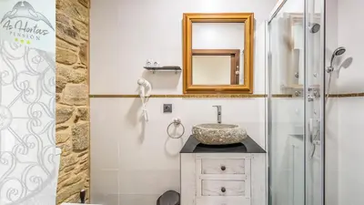 a bathroom with a sink and a mirror at Pensión As Hortas in Palas de Rei
