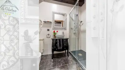 a bathroom with a black vanity and a mirror at Pensión As Hortas in Palas de Rei
