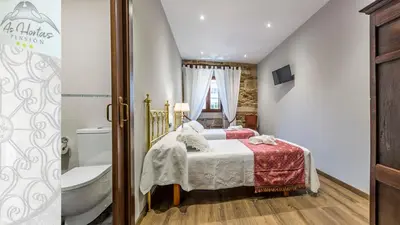 a bedroom with a bed and a toilet and a tub at Pensión As Hortas in Palas de Rei