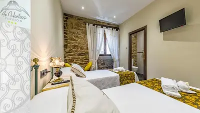 a hotel room with two beds and a tv at Pensión As Hortas in Palas de Rei