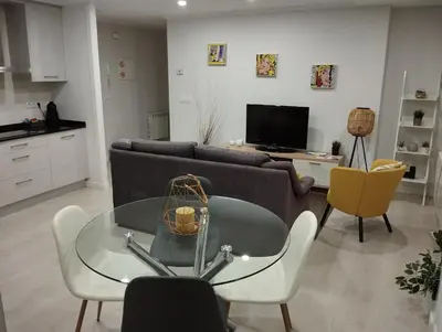 a living room with a couch and a glass table at Alojamiento Buenos Aires in Ourense