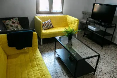 a living room with a yellow couch and a tv at Casona de Rabanal-Oca in Rabanal del Camino