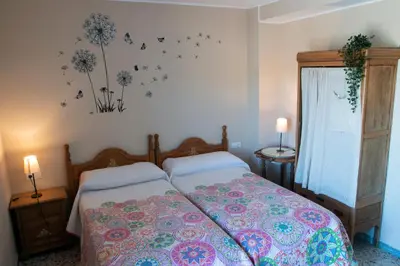 a bedroom with a bed with flowers and butterflies on the wall at Casona de Rabanal-Oca in Rabanal del Camino