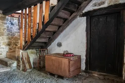 an old room with a wooden door and stairs at Casona de Rabanal-Oca in Rabanal del Camino