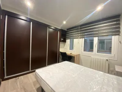 a bedroom with a bed and a desk and a window at Residencia Compostela in Santiago de Compostela