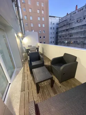 a balcony with chairs and a couch on a building at Residencia Compostela in Santiago de Compostela
