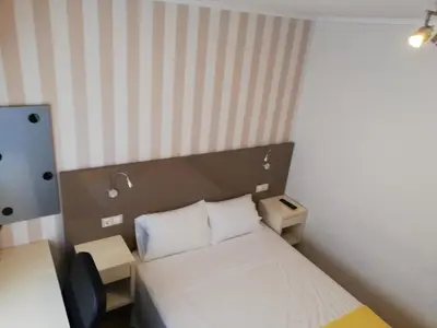 a small room with a bed and a desk at Residencia Compostela in Santiago de Compostela