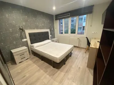 a small bedroom with a bed and a window at Residencia Compostela in Santiago de Compostela