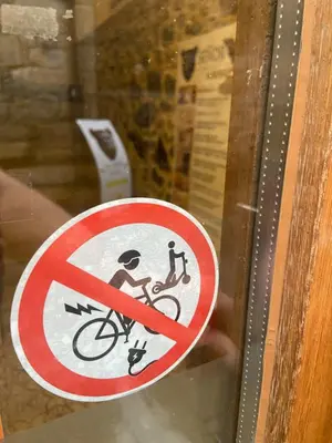 a sign on a window with a person on a bike at SEÑOR OSO in Molinaseca