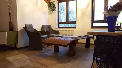a room with a table and chairs and windows at La Posada del Druida in Foncebadón