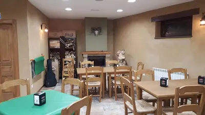 a restaurant with tables and chairs and a fireplace at La Posada del Druida in Foncebadón