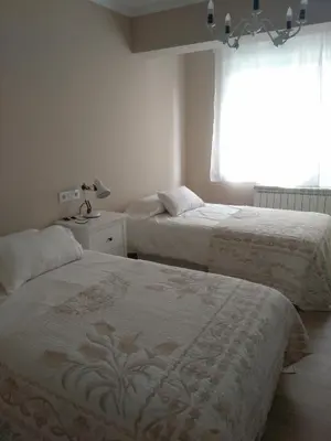 a bedroom with two beds and a window at Torre Center II in Santiago de Compostela