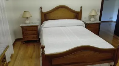 a bedroom with a wooden bed with two night stands at Casa Braña in Barreiros