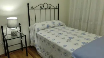 a small bedroom with a bed with a metal frame at Casa Braña in Barreiros