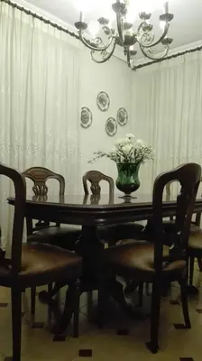 a dining room table with chairs and a vase of flowers at Casa Braña in Barreiros
