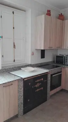 a kitchen with wooden cabinets and a counter top at Casa Braña in Barreiros