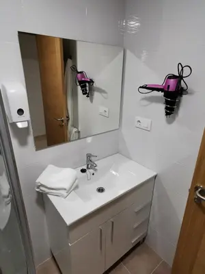 a white bathroom with a sink and a mirror at Duerming Family Viveiro 3 Rooms in Viveiro