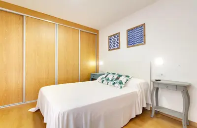 a bedroom with a white bed and wooden cabinets at Duerming Family Viveiro 3 Rooms in Viveiro