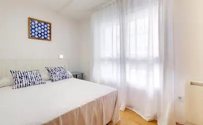 a white bedroom with a bed and a window at Duerming Family Viveiro 3 Rooms in Viveiro