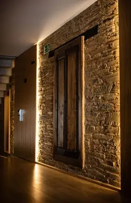 a room with a brick wall with a wooden door at A Casa da Botica in Samos