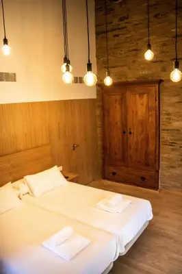 two beds in a room with two white towels at A Casa da Botica in Samos